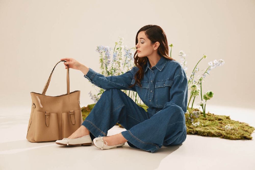 femeie îmbrăcată în costum din denim cu balerini și geantă maro